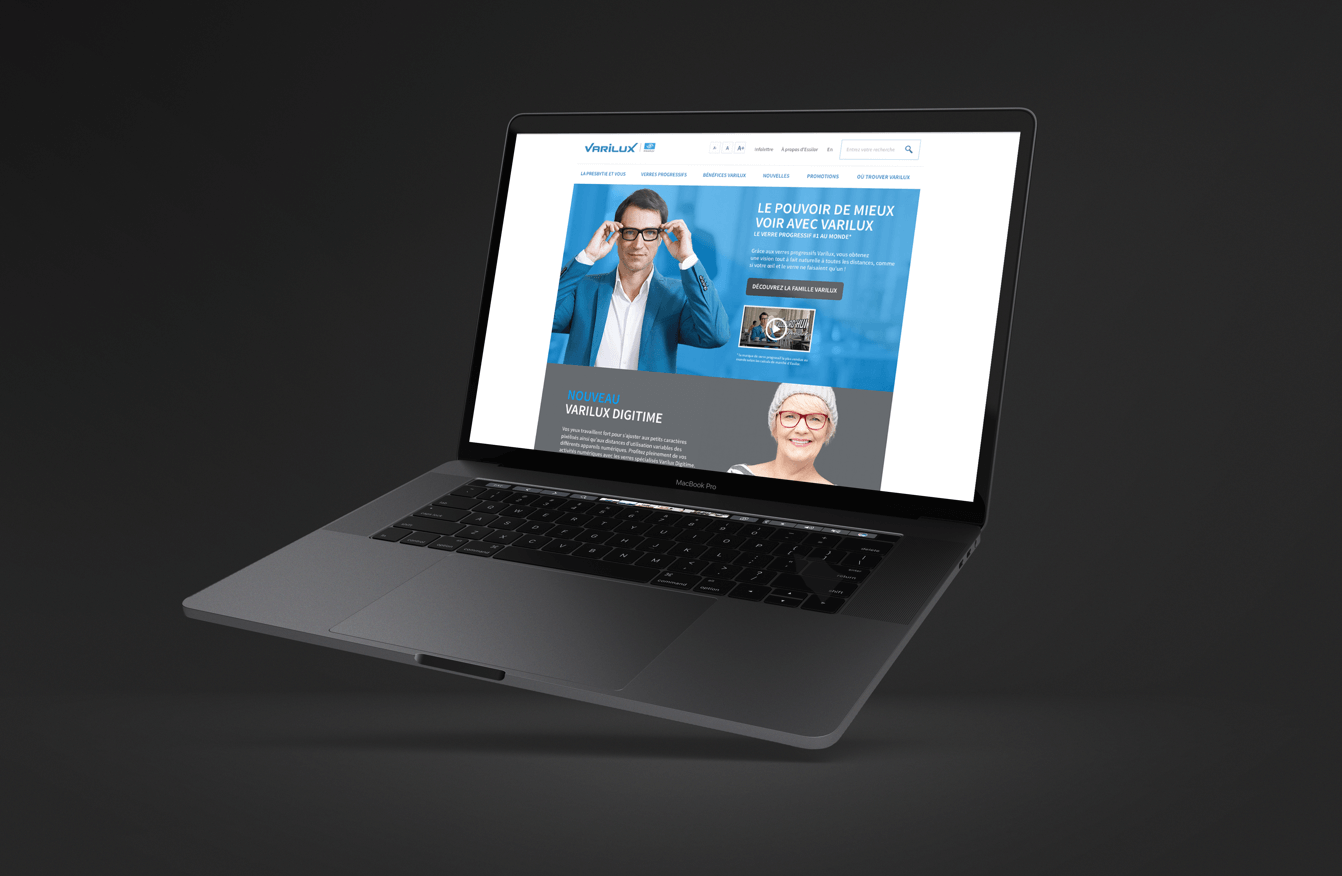 Portable avec à l'écran site web Varilux en gris et bleu ciel avec des personnes portant des lunettes
